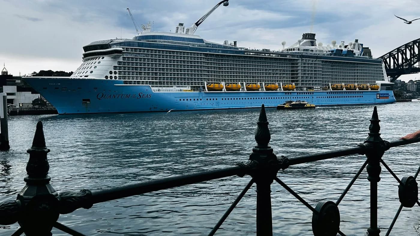 Royal Caribbean cruise ship moored beside a harbor promenade